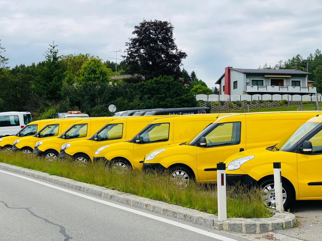 Gelbe Ex-Post-Transporter in einer Reihe bei KFZ Cokic
